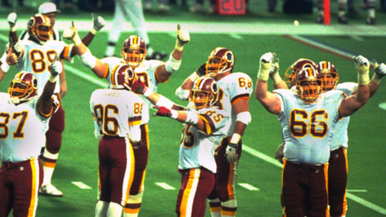 Washington Redskins offensive linemen and teammates celebrate on the field with raised arms during Super Bowl XXVI